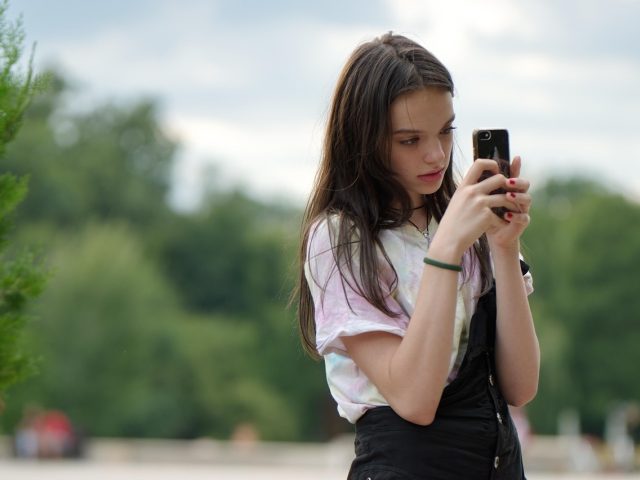 模型下载主编林知远坐在编辑室的窗边，手里拿着一份打印的版本对照表低头核对，桌上放着一支旧钢笔与摊开的笔记本，午后光线落在肩头，神情专注平和